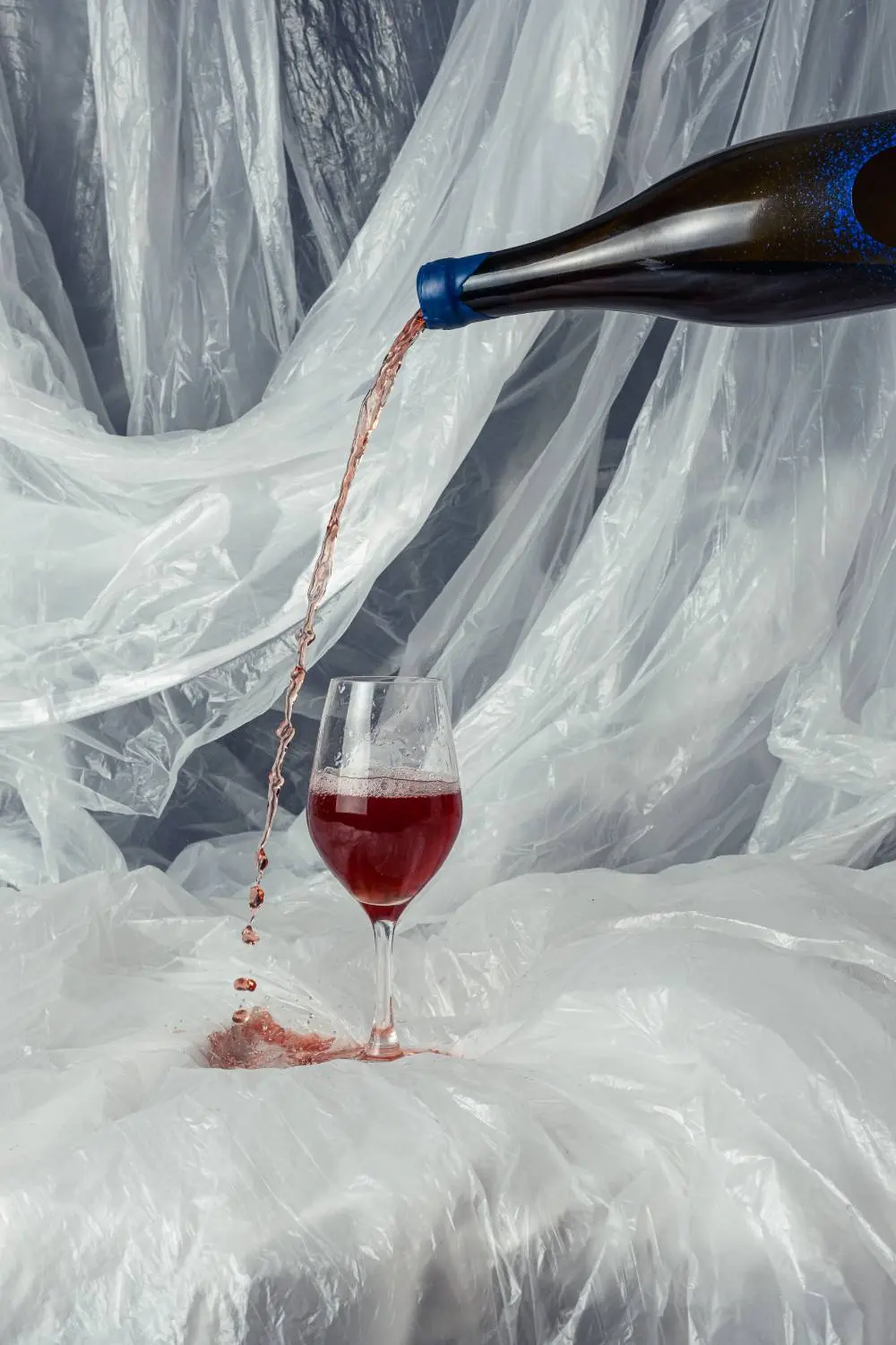 Pouring natural wine bottle outside wine glass.